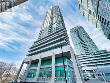 Toronto (Bendale) condo for rent - A tall building with a glass facade stands in front of other buildings.