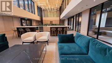 Oakville (Jm Joshua Meadows) condo for rent - A modern living room with a dark wood coffee table and a teal sofa.
