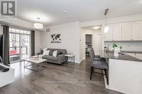 Oakville (Ro River Oaks) townhouse for rent - A well-lit, modern kitchen and living room with a grey sofa and a coffee table.