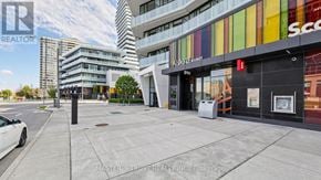Mississauga (City Centre) condo for rent - A street view of a city with a white car parked on the side of the road.