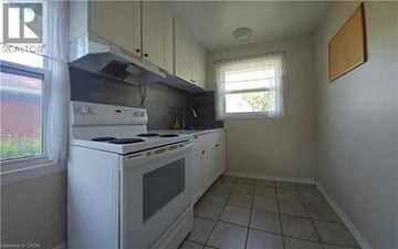 Hamilton apartment for rent - A white stove and oven in a kitchen with white cabinets.