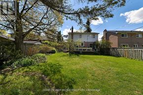 Markham (Grandview) apartment for rent - A backyard with a lawn and a tree in front of a house.