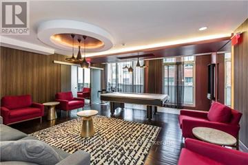 Toronto (Moss Park) condo for rent - A living room with a red sofa, a grey sofa, a round table and a television.
