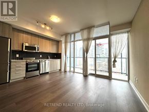 Toronto (Moss Park) condo for rent - A spacious kitchen with wooden floors and stainless steel appliances.