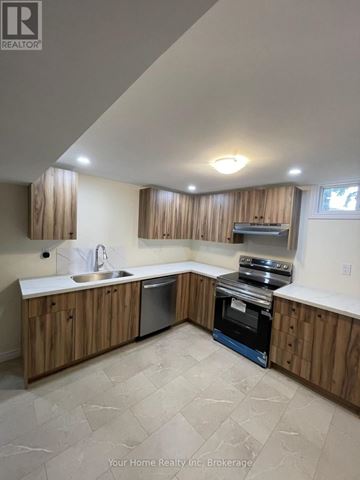 Kitchener apartment for rent - A kitchen with wooden cabinets and a stove top oven.
