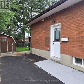 Kitchener apartment for rent - A brick house with a driveway in front.