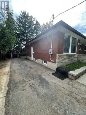 Kitchener apartment for rent - A brick house with a driveway in front.