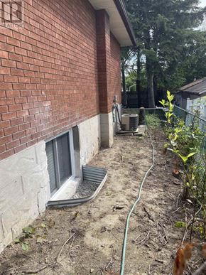 Kitchener apartment for rent - A red brick house with a window and a hose.