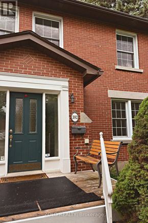 Ottawa apartment for rent - A red brick house with a green door and a bench outside.