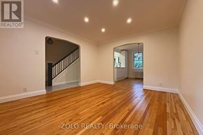 Ottawa apartment for rent - A spacious room with wooden flooring and a staircase.