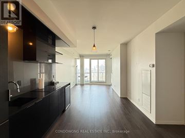 Toronto (Bay Street Corridor) condo for rent - A modern kitchen with dark wood floors and a large window.