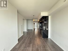 Toronto (Bay Street Corridor) condo for rent - A long, empty hallway with wood flooring and white walls.
