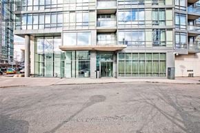 Toronto (Waterfront Communities) condo for rent - A modern building with glass windows and a large entrance.