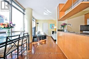 Toronto (Waterfront Communities) condo for rent - A well-lit kitchen with wooden floors and a dining table with chairs.