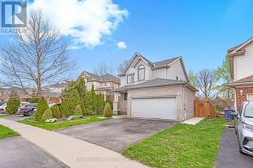 Guelph (Kortright Hills) apartment for rent - A residential area with a house and a car parked in front.
