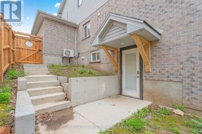 Guelph (Kortright Hills) apartment for rent - A house with a wooden fence and a concrete staircase leading to a glass door.