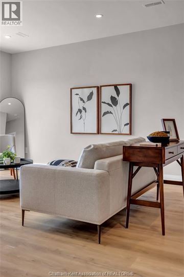Blenheim apartment for rent - A living room with a couch, a chair, and a table with a plant on it.