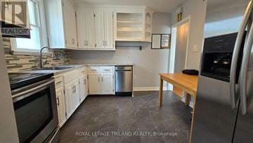London East (East O) apartment for rent - A kitchen with white cabinets and a wooden table.