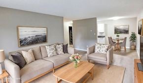 Surrey apartment for rent - A living room with a grey couch, a wooden coffee table, and a painting on the wall.