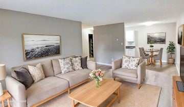 Surrey apartment for rent - A living room with a grey couch, a wooden coffee table, and a painting on the wall.