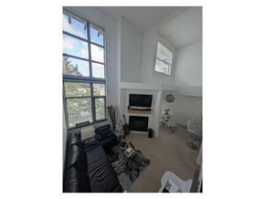 Surrey apartment for rent - A living room with a black couch and a television.