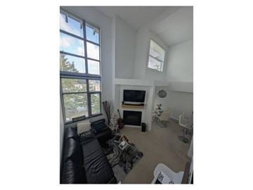 Surrey apartment for rent - A living room with a black couch and a television.