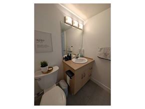 Surrey apartment for rent - A bathroom with a white toilet and a wooden vanity with a white sink.