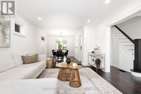 Toronto (East York) apartment for rent - A well-lit, spacious living room with a white sofa, wooden coffee table, and a staircase on the right.