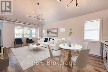 Toronto (The Beaches) multi-family for rent - A modern living room with a dining table set up with white chairs.