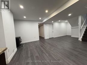 Georgina (Keswick North) apartment for rent - A spacious room with wood flooring and white walls, with a staircase on the right side.
