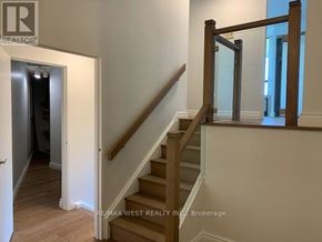 Toronto (Markland Wood) condo for rent - A staircase with a wooden handrail and white walls.