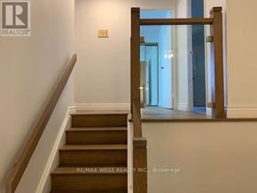 Toronto (Markland Wood) condo for rent - A staircase with a wooden handrail and steps leading to a bright room.