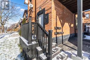 Toronto (Runnymede-Bloor West Village) apartment for rent - A brick house with a black door and a wooden porch.