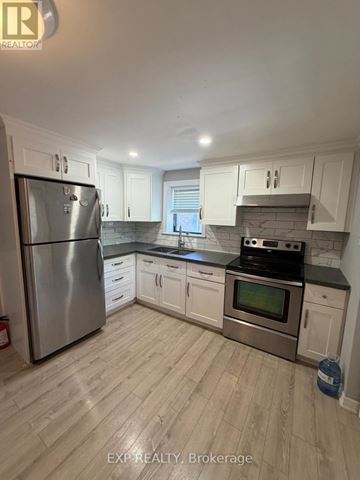 Toronto (Runnymede-Bloor West Village) apartment for rent - A kitchen with white cabinets and a stainless steel refrigerator.