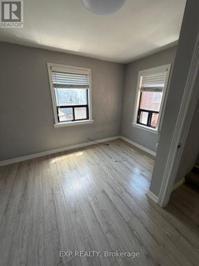 Toronto (Runnymede-Bloor West Village) apartment for rent - A room with wooden flooring and two windows.