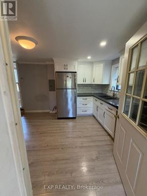 Toronto (Runnymede-Bloor West Village) apartment for rent - A kitchen with wooden floors and white cabinets.