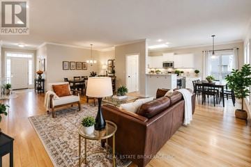 London North (North B) house for rent - A well-lit, spacious living room with a brown sofa and a glass coffee table.