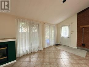 Niagara Falls (West Wood) apartment for rent - A living room with a fireplace and a door leading to a hallway.
