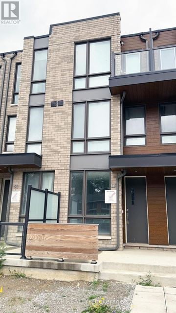 Toronto (Englemount-Lawrence) townhouse for rent - A modern apartment building with a wooden front door and glass windows.