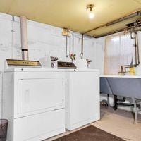 Victoria apartment for rent - A white oven and fridge in a kitchen with a table and chairs.