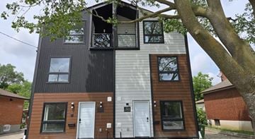 North York apartment for rent - A modern two-story house with a mix of dark and light wooden siding.