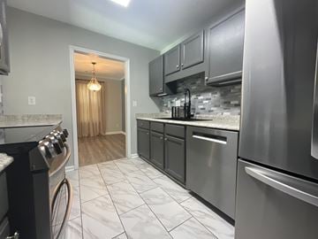 Clemmons apartment for rent - A kitchen with a stove top oven and a refrigerator.