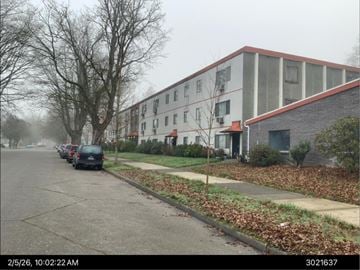 Longview apartment for rent - A street with cars parked on the side and a building in the background.