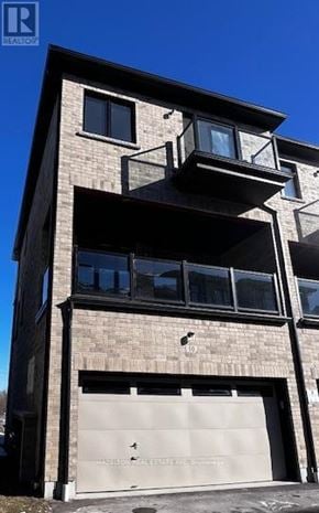 Whitby (Port Whitby) townhouse for rent - A modern building with a garage door and balconies.