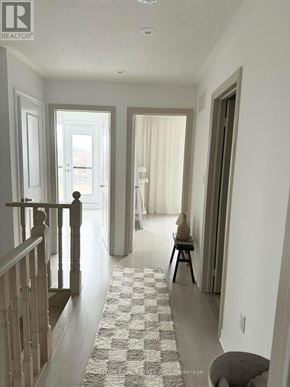 Whitby (Port Whitby) townhouse for rent - A hallway with a checkered rug and a wooden railing.