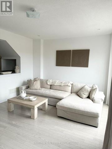 Whitby (Port Whitby) townhouse for rent - A living room with a white couch and a wooden coffee table.