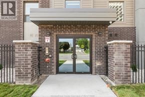 Windsor condo for rent - The entrance to a building with a glass door and a brick wall.