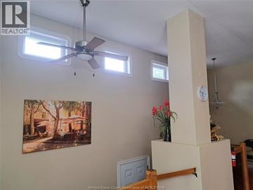 Windsor apartment for rent - A living room with a ceiling fan, a clock, and a painting on the wall.