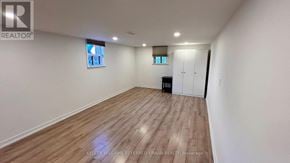 Toronto (Stonegate-Queensway) apartment for rent - A spacious room with wooden flooring and white walls.