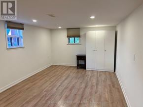 Toronto (Stonegate-Queensway) apartment for rent - A room with wooden flooring and a white wall.